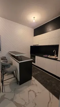 Modern kitchen with a bar counter and bar stools. - image 4