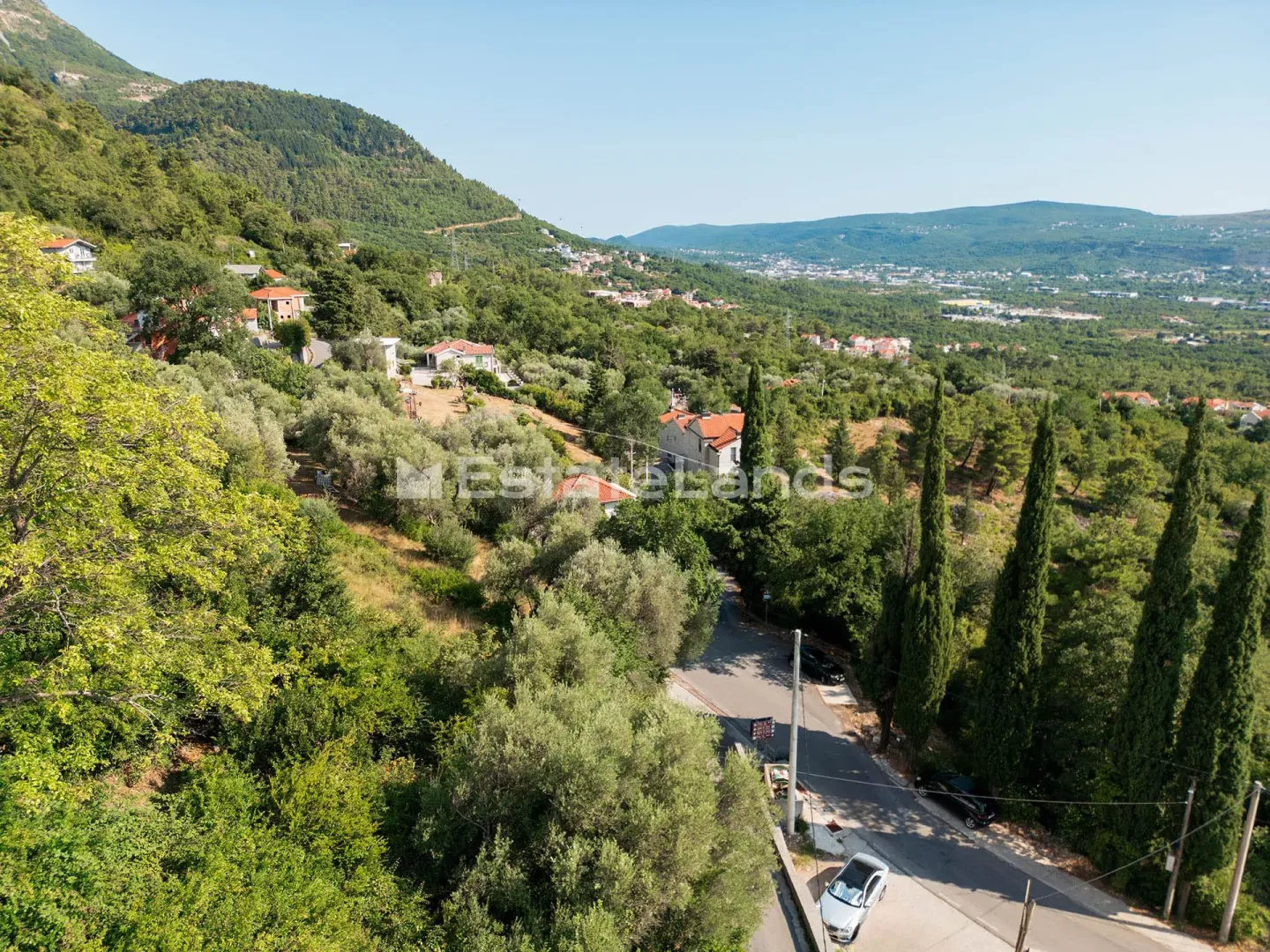 Pogled iz vazduha na okolinu sa zelenilom i kućama.