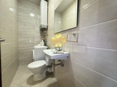 Small bathroom with a toilet, sink, and water heater. - image 7