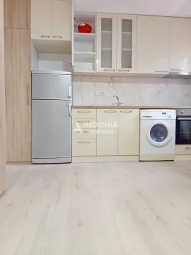 Kuhinja opremljena svetlim elementima, frižiderom i ugrađenim uređajima. - image 6