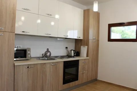 Modern kitchen with light wooden elements and white upper cabinets. - image 2