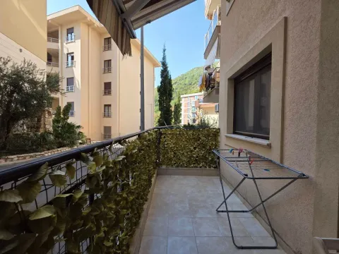 Natkriveni balkon sa stalkom za sušenje veša i pogledom na okolne zgrade. - image 11