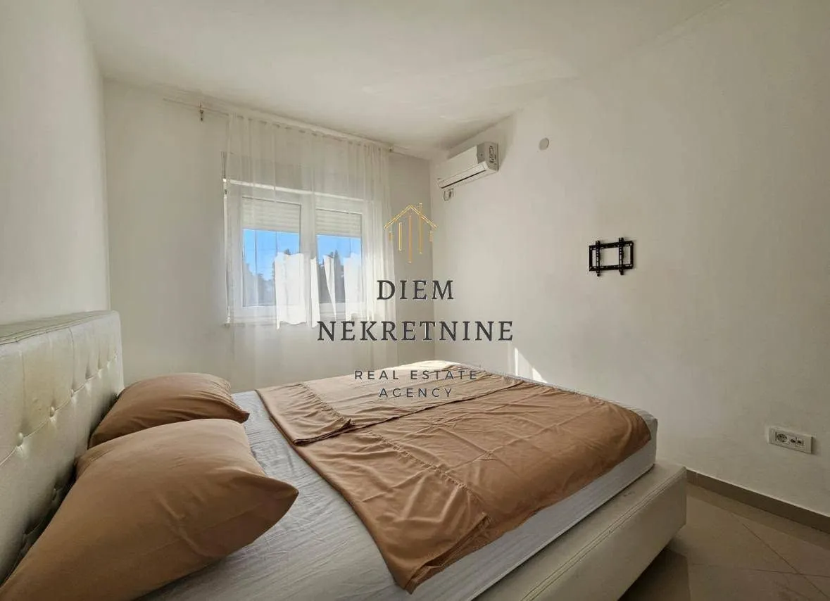 Furnished bedroom with a double bed and air conditioning.
