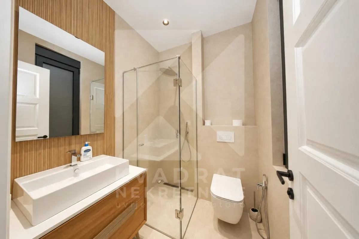 Modern bathroom with a walk-in shower, washbasin, and built-in sanitaryware.