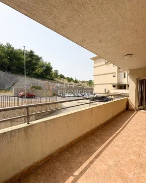 Prostrani natkriveni balkon sa pogledom na parking i okolno zelenilo. - image 6