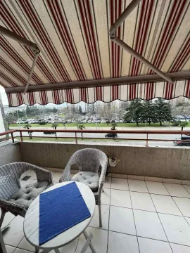 Balkon sa garniturom za sjedenje i prugastom tendom. - image 3