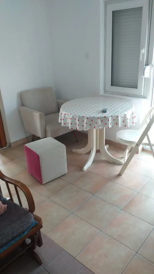 Part of a room with a round table and an armchair.