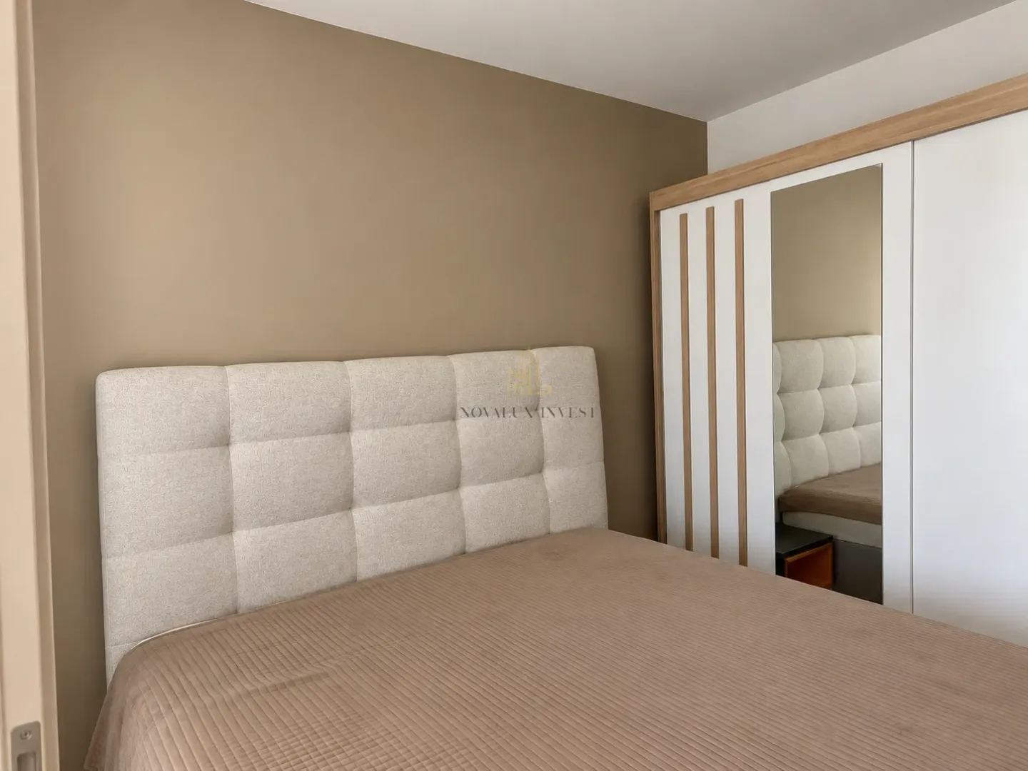 Furnished bedroom with a double bed and a wardrobe with a mirror.
