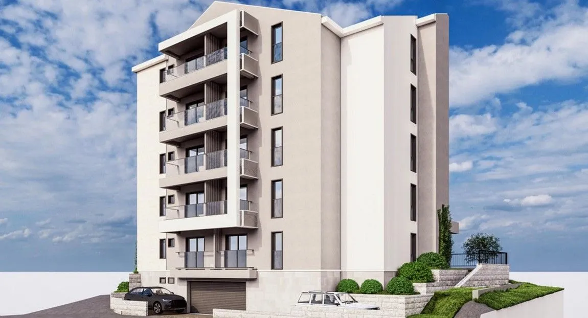 Exterior view of a modern residential building with balconies and a basement garage.