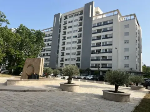 Exterior view of the residential building with a landscaped square and greenery. - image 3
