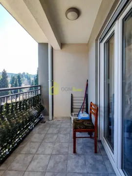 Covered balcony space with glass doors and a view of greenery. - image 8