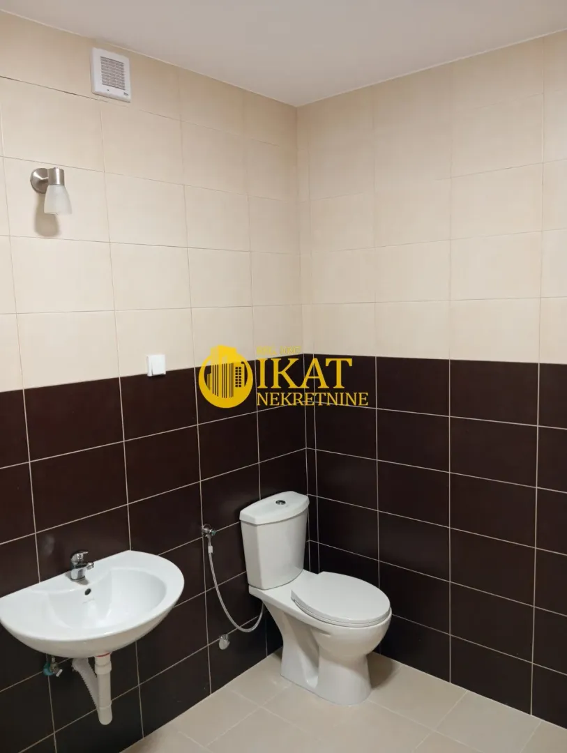 Smaller bathroom tiled in two colors with a washbasin and toilet bowl.