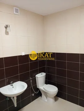 Smaller bathroom tiled in two colors with a washbasin and toilet bowl. - image 12