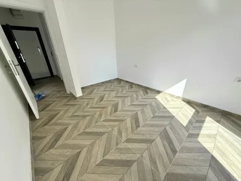 Empty room with herringbone laminate flooring and white walls. - image 4