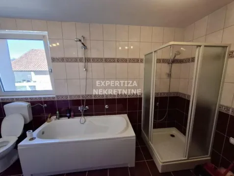 Bathroom equipped with a bathtub, shower cabin, and sanitary fixtures. - image 15