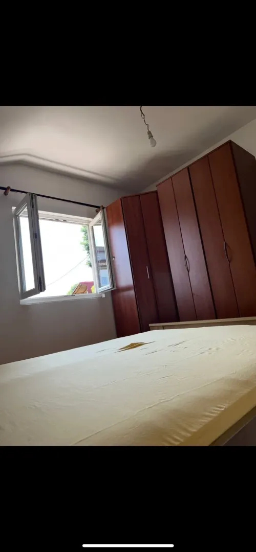 Furnished bedroom with a double bed and a wardrobe.