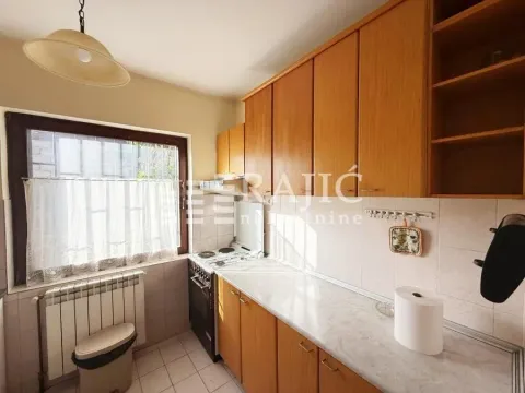 Older kitchen with wooden cabinets and a stove. - image 5