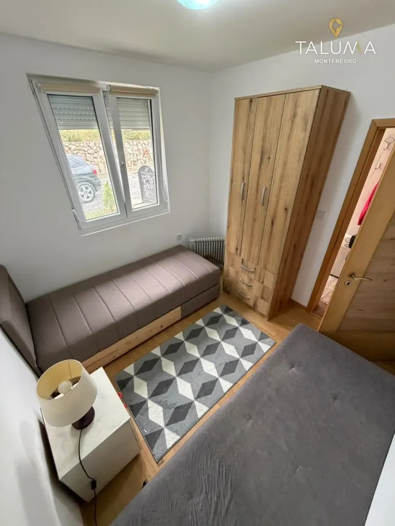 Small bedroom with two beds, a wardrobe, and a window.
