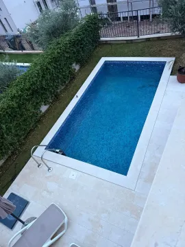 Top-down view of an outdoor swimming pool with a paved patio and landscaped yard. - image 19
