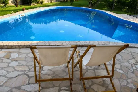 Yard with a swimming pool and sun loungers. - image 4
