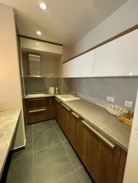 Small kitchen with wooden base cabinets and white upper cabinets. - image 4
