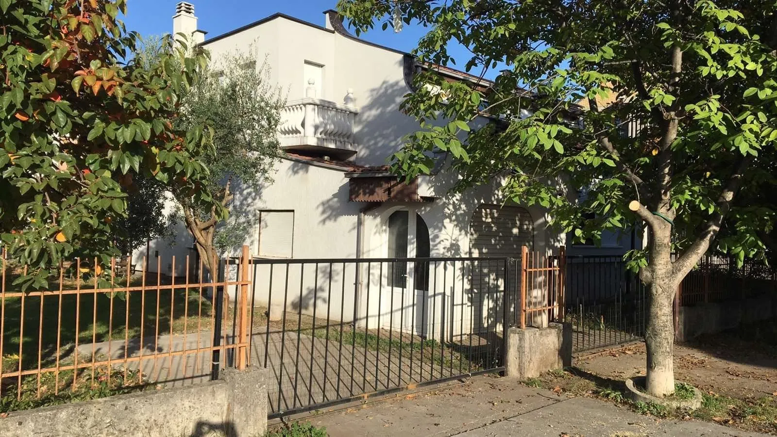 Exterior of a two-story house with a fenced yard.