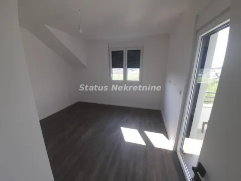 Prazna soba sa tamnim laminatom i belim zidovima. - image 11