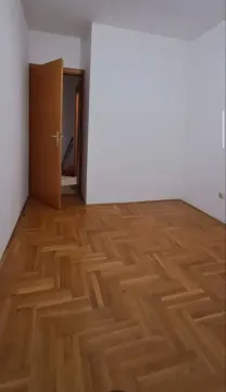 Prazna soba sa parketom i otvorenim drvenim vratima. - image 5
