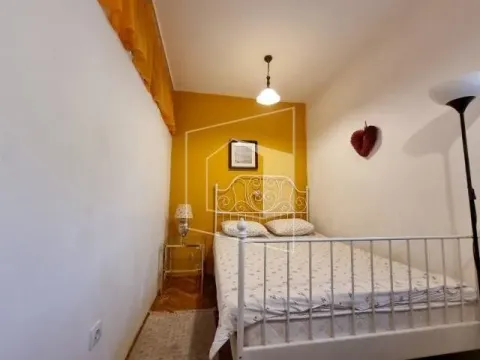 Smaller bedroom with a double bed and yellow wall accents. - image 13
