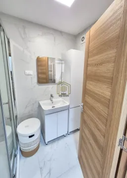 Moderne kupatilo sa tuš kabinom, umivaonikom i bijelim elementima. - image 4
