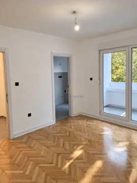 Prazna soba sa drvenim parketom i izlazom na terasu. - image 4