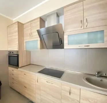 Modern kitchen with wooden cabinetry and built-in appliances. - image 3