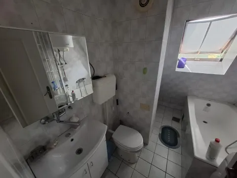 Kupatilo opremljeno umivaonikom, ormarićem sa ogledalom, toaletom i kadom. - image 8