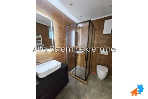 Bathroom with a walk-in shower, washbasin, and toilet, finished with ceramic tiles. - image 18