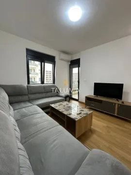 Dnevna soba sa ugaonom garniturom, televizorom i izlazom na terasu. - image 2