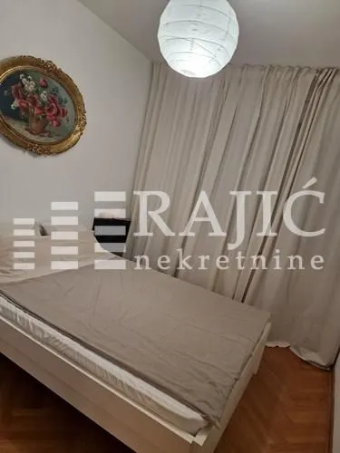 Nameštena spavaća soba sa bračnim krevetom.