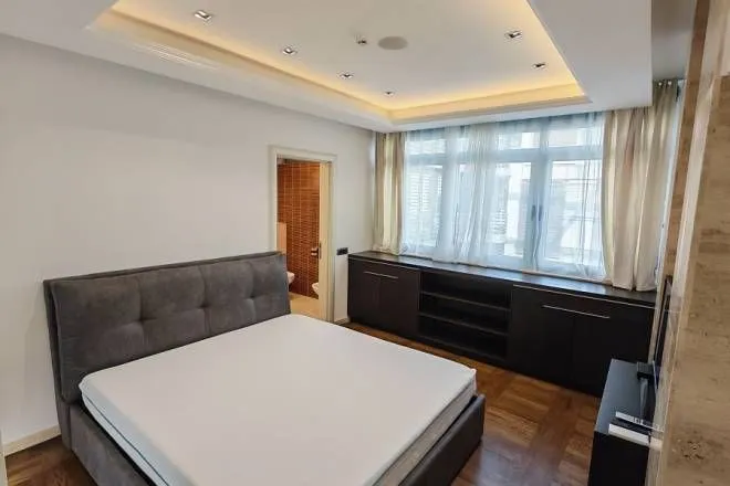 Spacious bedroom with a double bed, built-in cabinetry, and an en-suite bathroom.
