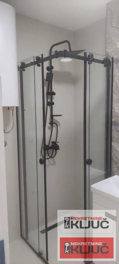 Moderna tuš kabina sa crnim slavinama u kupatilu.
