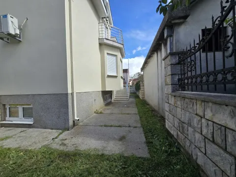Side of the house with a courtyard and paved pathways. - image 46
