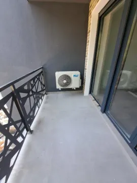 Manji balkon sa metalnom ogradom i spoljnom jedinicom klima uređaja. - image 10