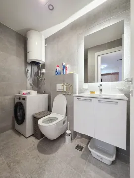 Moderno opremljeno kupatilo sa veš mašinom, wc šoljom i umivaonikom. - image 10
