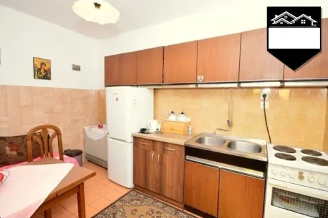 Older kitchen with wooden cabinets, a sink, and an electric stove. - image 2