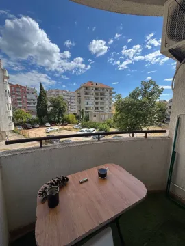 Manji namješten balkon sa stolom i pogledom na naselje. - image 10