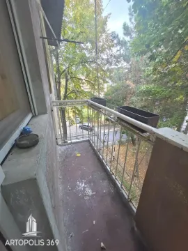 Manji balkon sa metalnom ogradom i pogledom na zelenilo i ulicu. - image 2