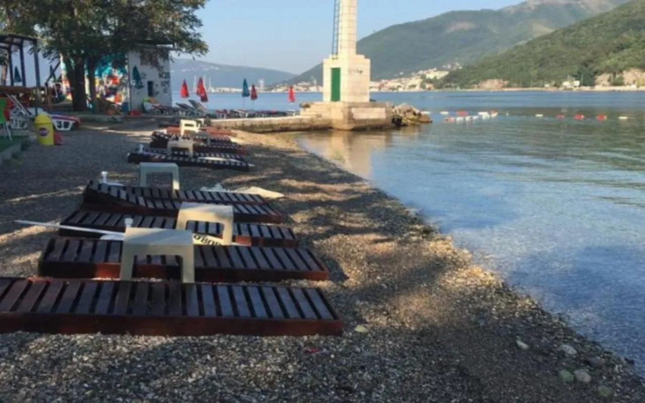 Pogled na plažu i obalu sa ležaljkama i molom.