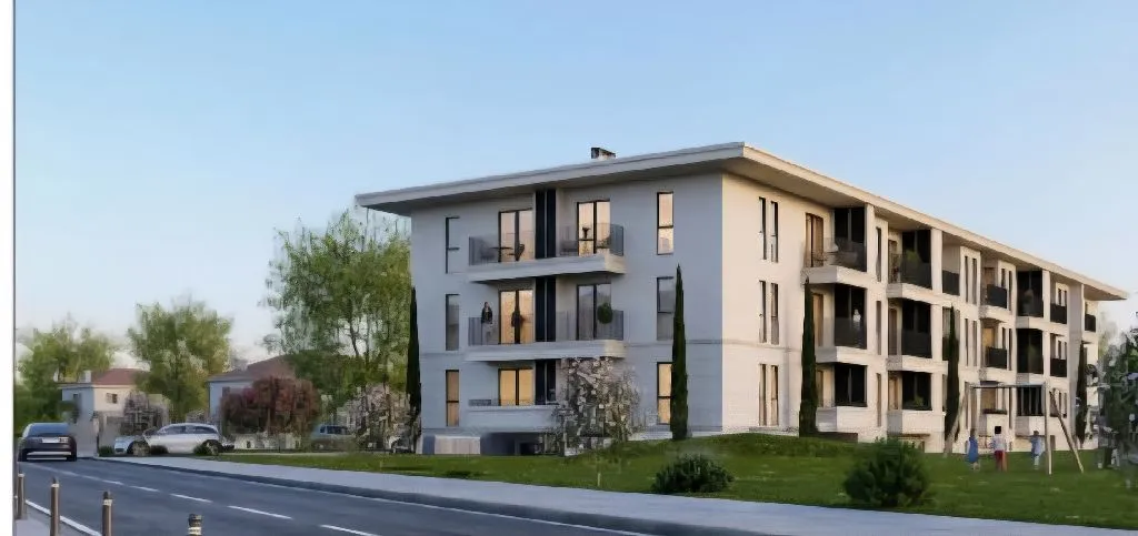 Spoljašnji izgled moderne stambene zgrade sa uređenim dvorištem.