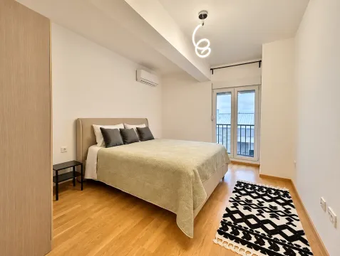 Bedroom with a double bed, wooden flooring, and access to a terrace. - image 5