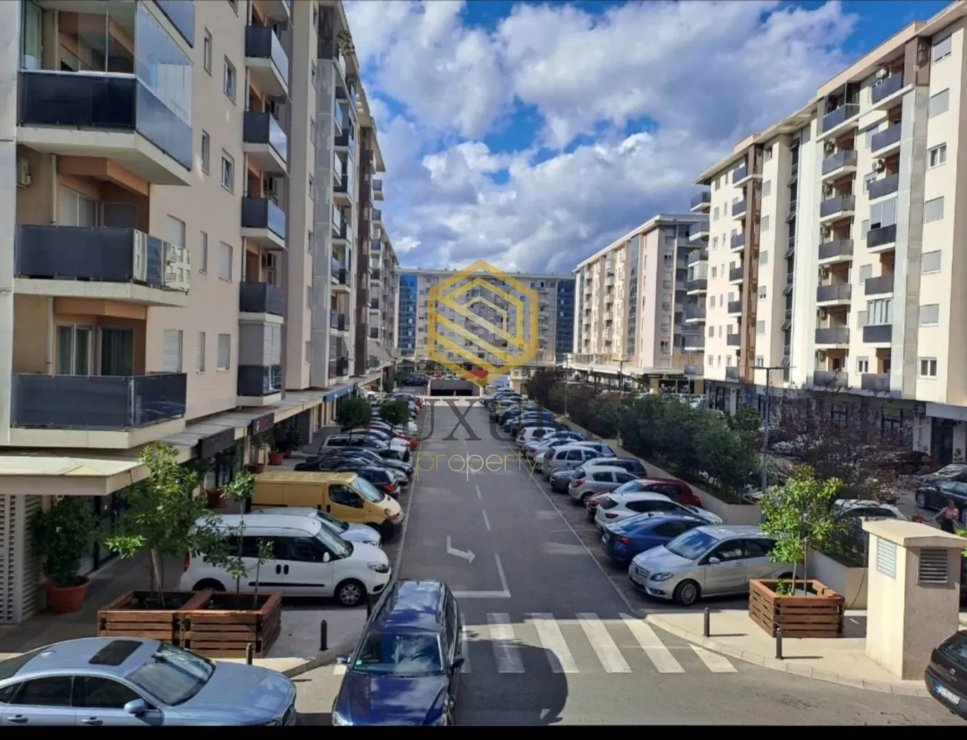 View from the terrace of residential buildings and parking in front of the complex.