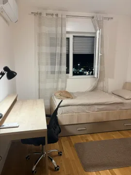 Small bedroom with a bed, desk, and window. - image 12