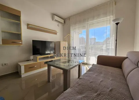 Living room with a sofa, TV, and air conditioning. - image 5